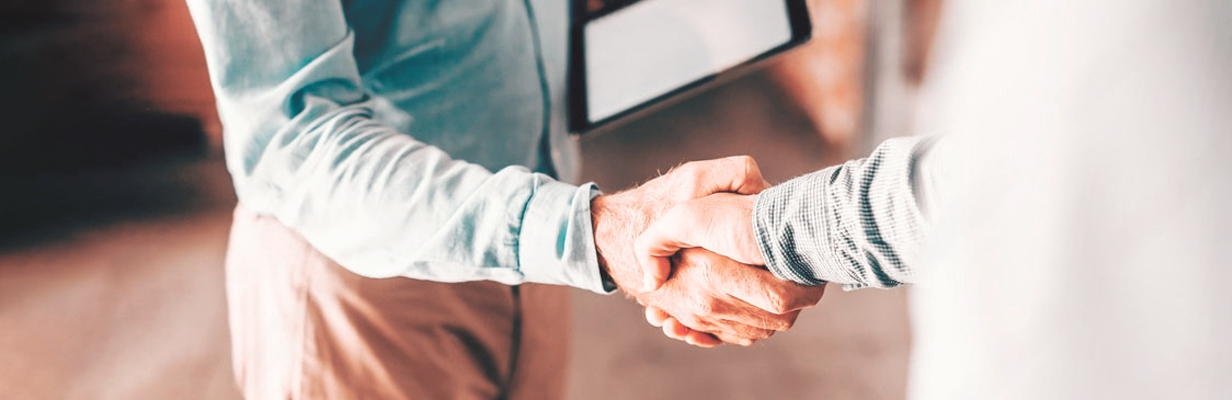 Dois homens a darem um aperto de mão - parceria e oportunidades para revendedores na Americana
